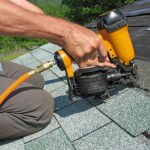 roofer attaching new shingles to roof