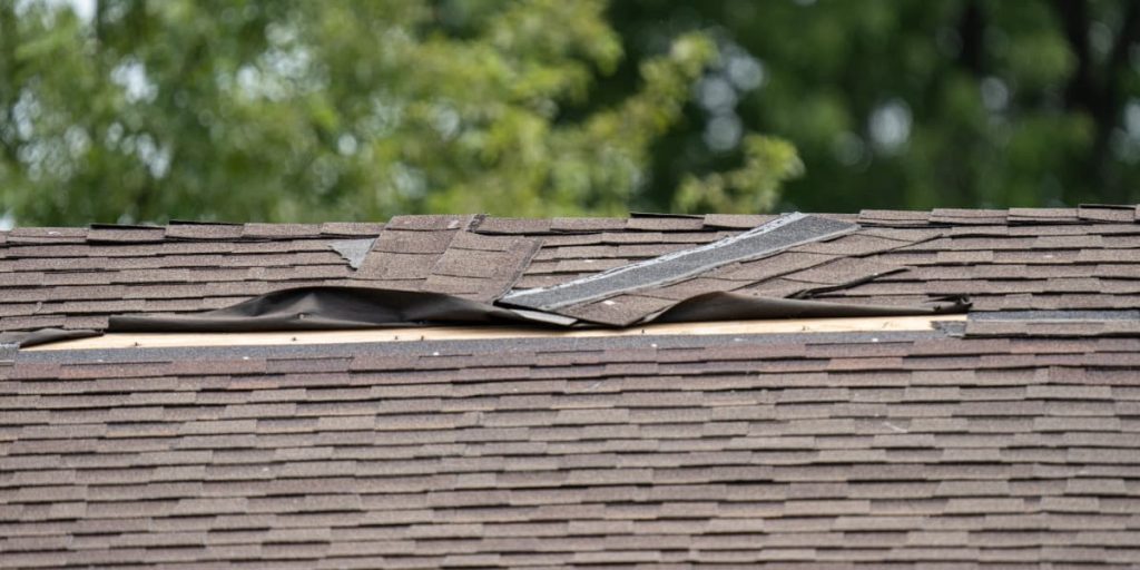 roof that requires storm damage repair with broken shingles