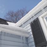 home with gutters covered in snow during winter